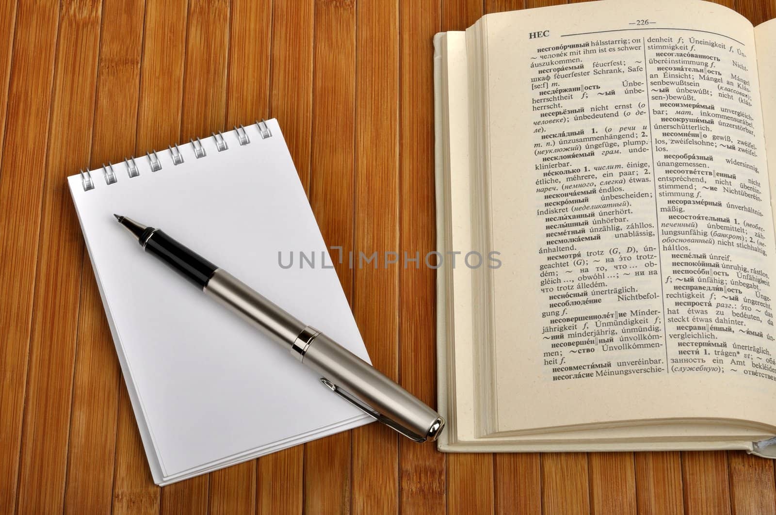 notebook with pen and old Russian-German dictionary