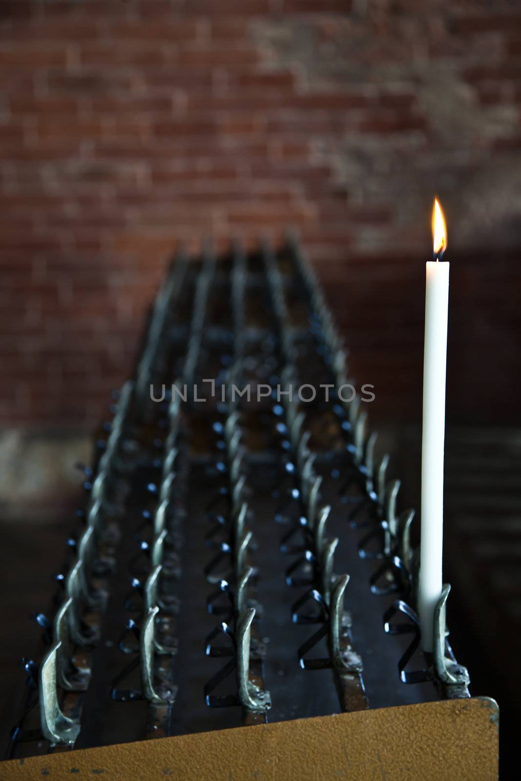 Lonely candle in a Italian Abbey. Concept of hope, faith, loneliness