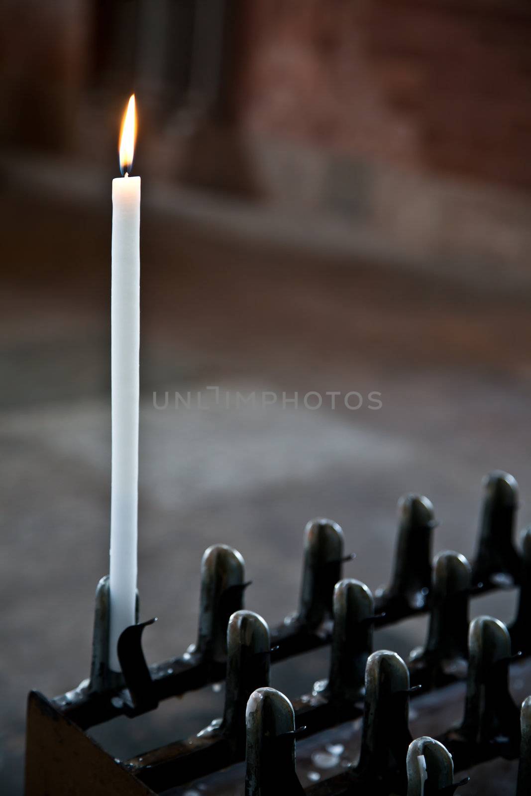 Lonely candle in a Italian Abbey. Concept of hope, faith, loneliness