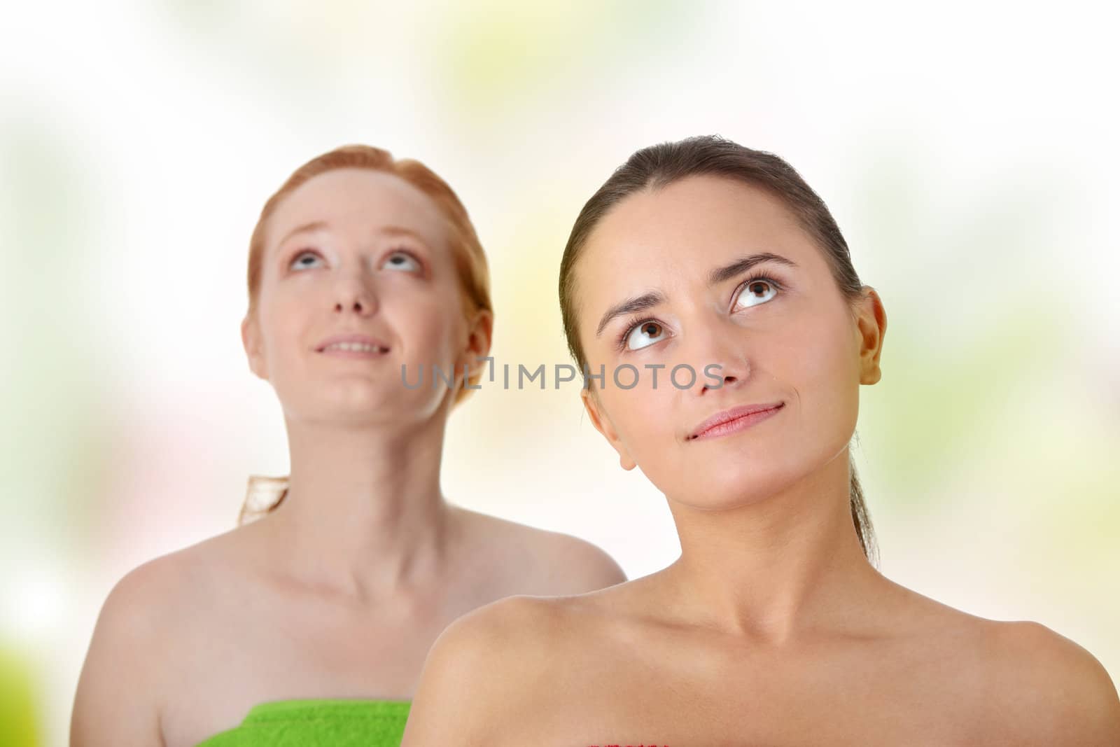 Spa - portrait of two woman - redhead and brunette - looking up