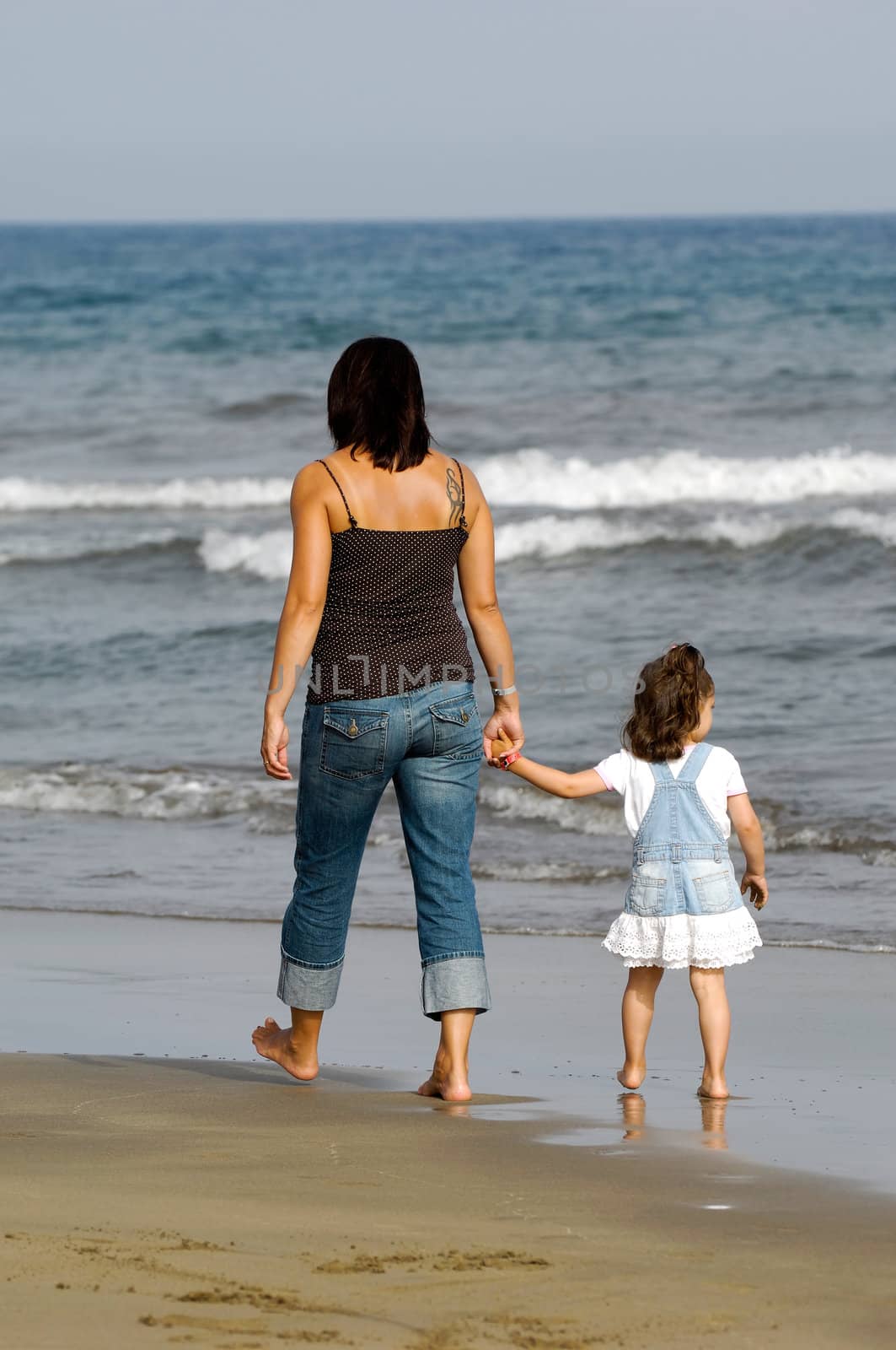 Mother and daughter together at the beach. 
