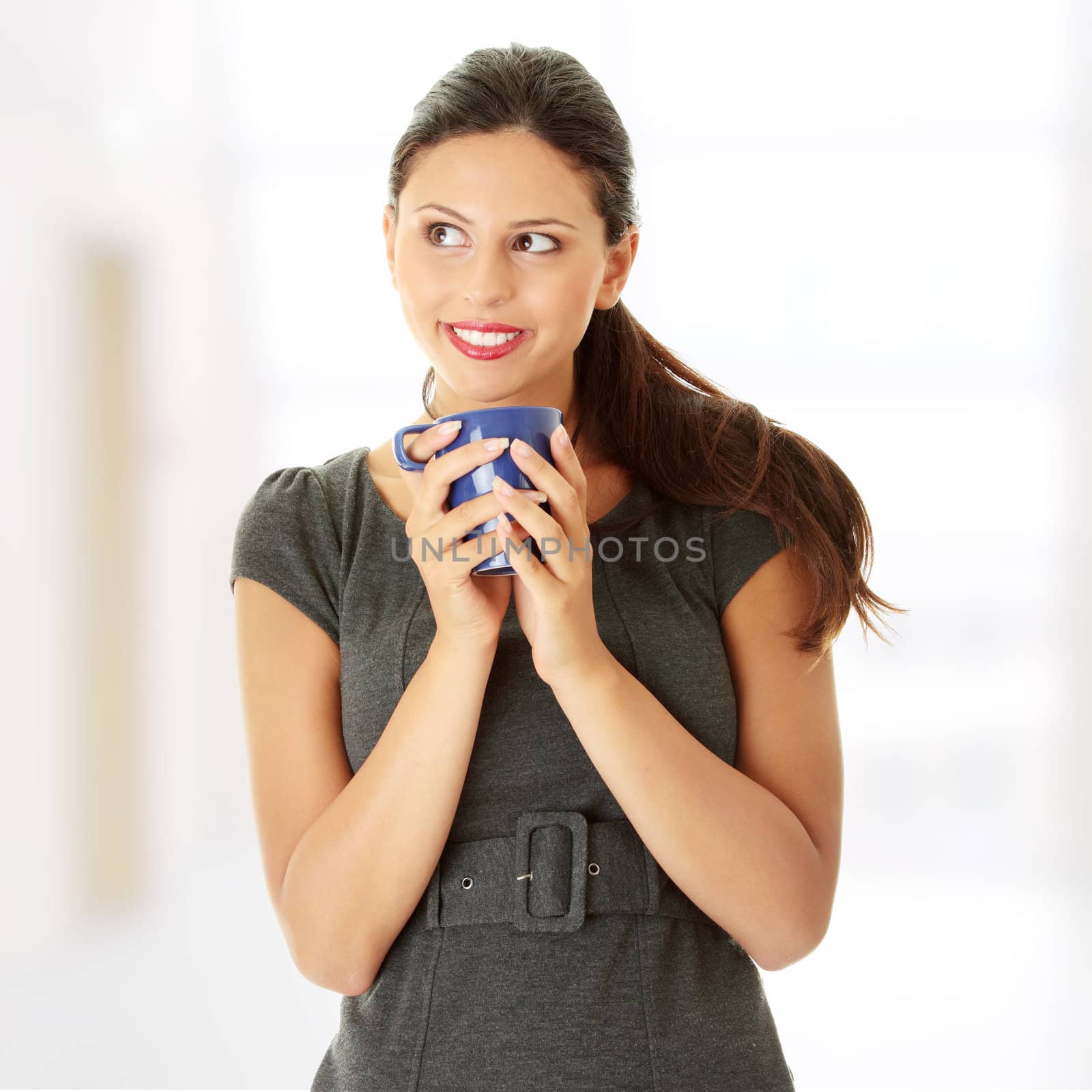 Portrait of cheerful businesswoman holding coffee cup
