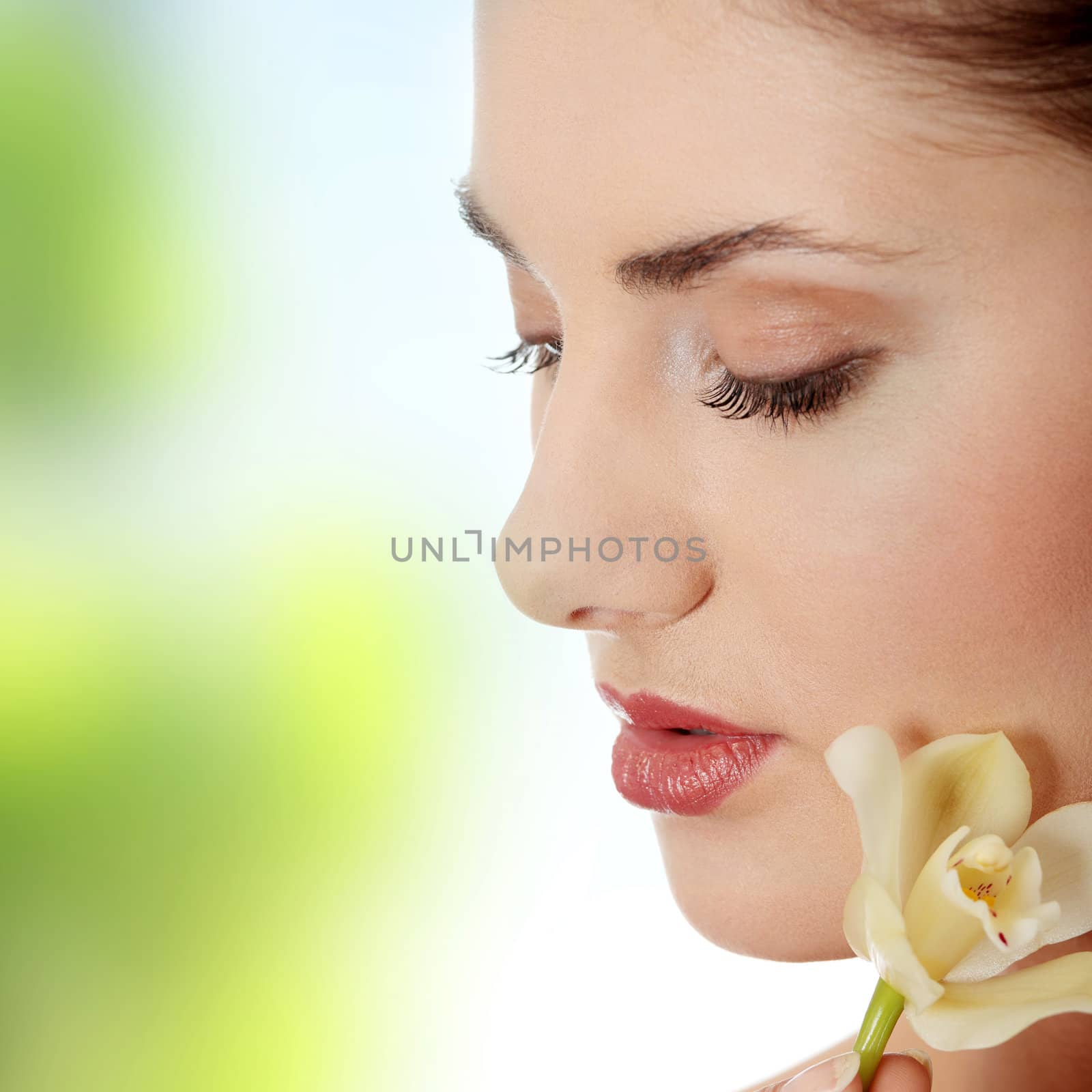 Beautiful woman holding orchid flower in her hands.