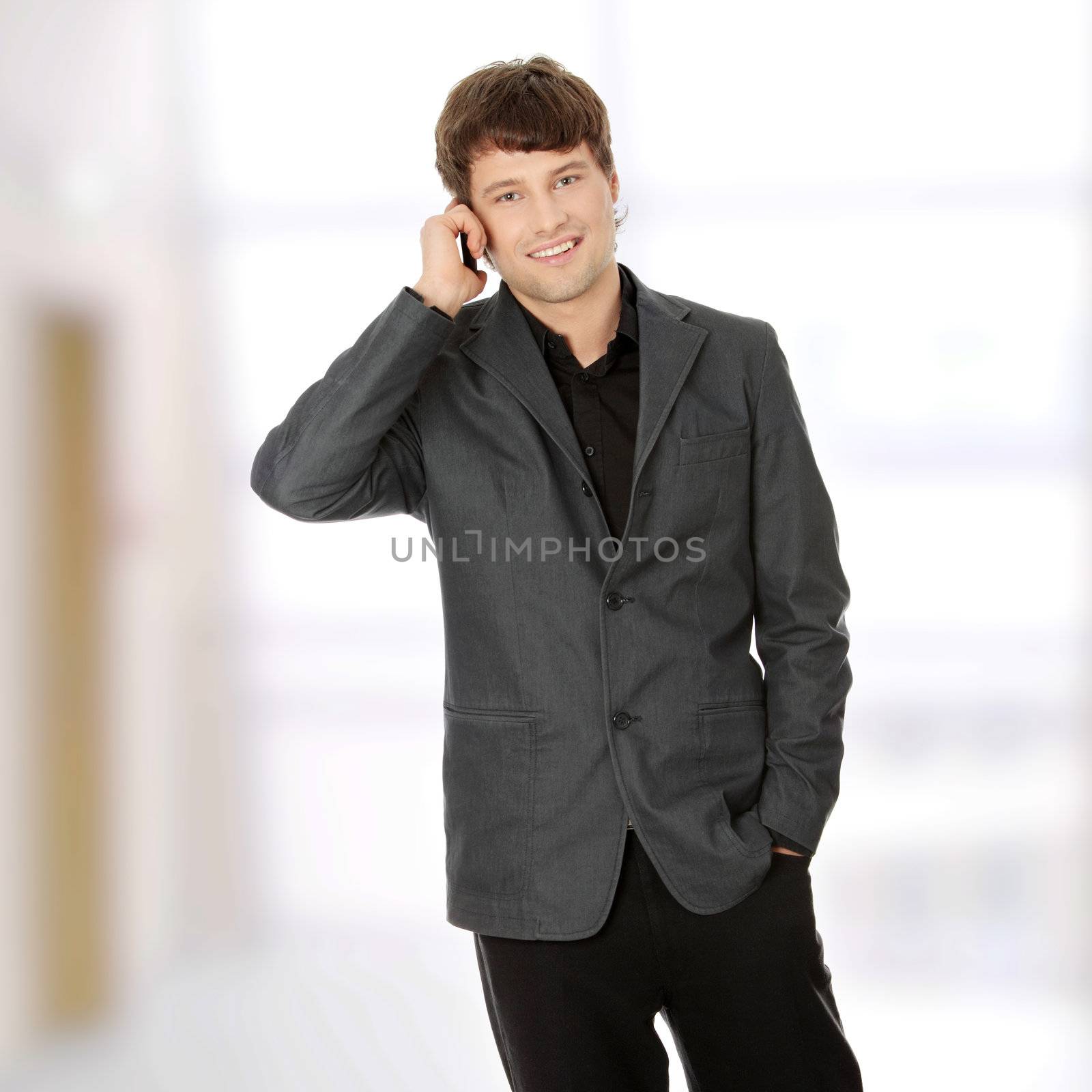 A handsome happy business man using mobile phone