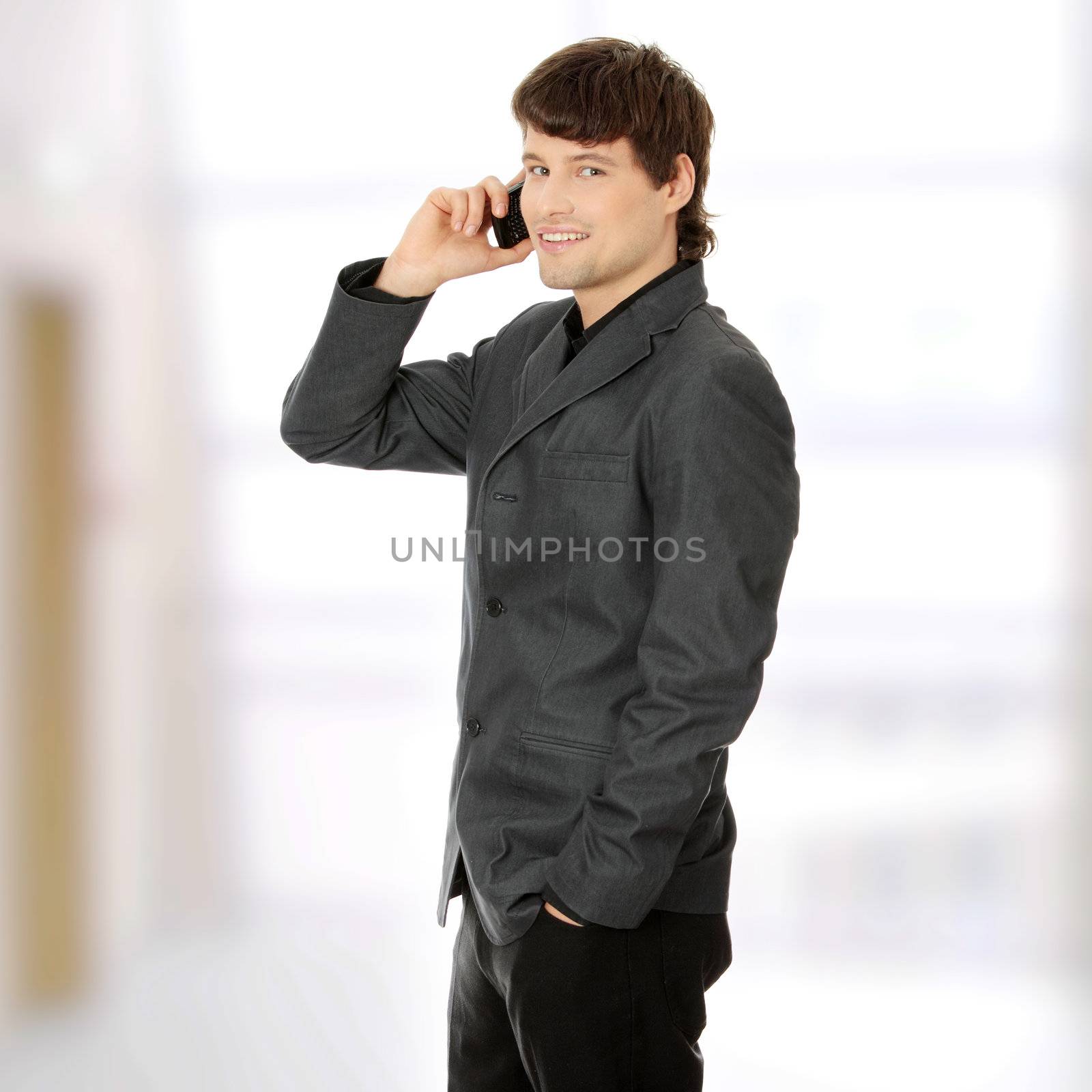 A handsome happy business man using mobile phone