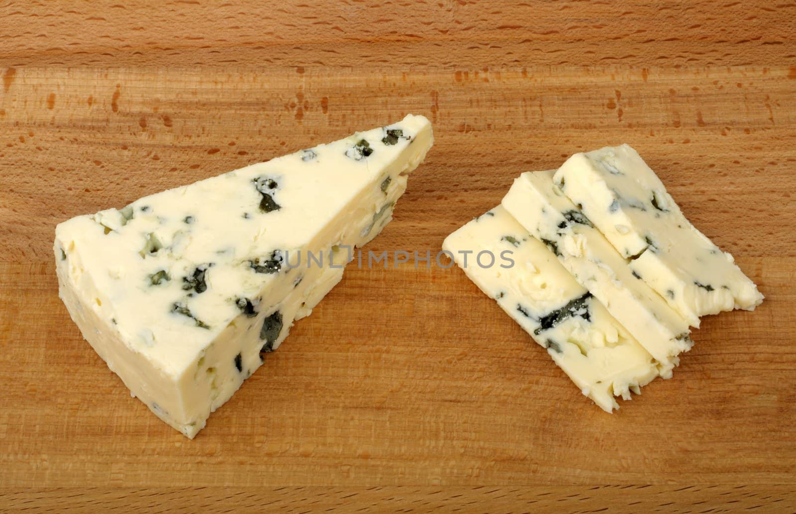 sliced blue cheese on a wooden cutting board