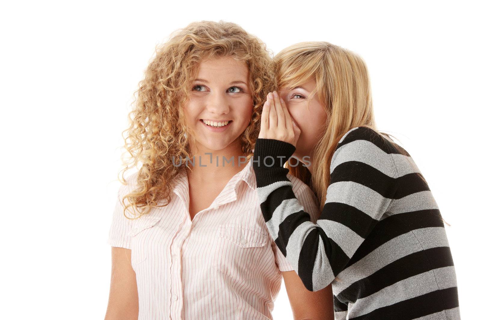 Two happy young girlfriends talking isolated over white