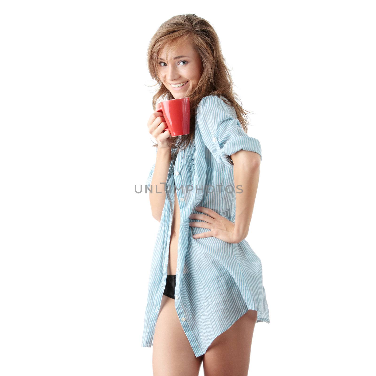 The beautiful young woman drinks morning coffee or tea