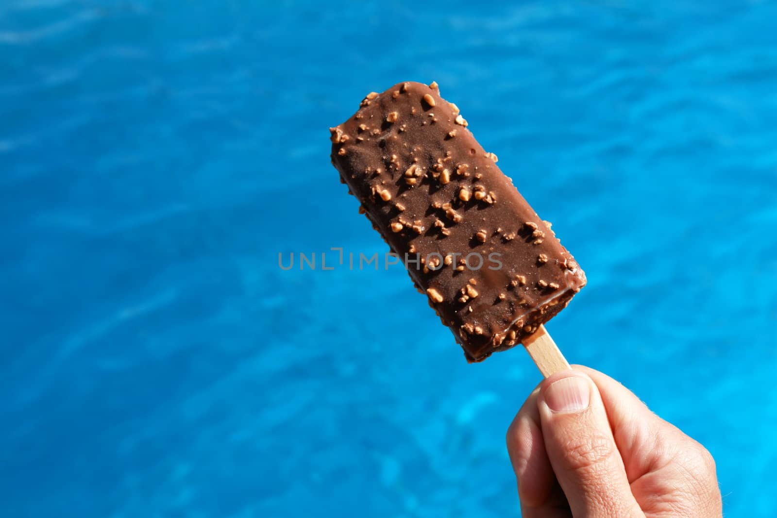 popsicle against a swimming pool on a hot day