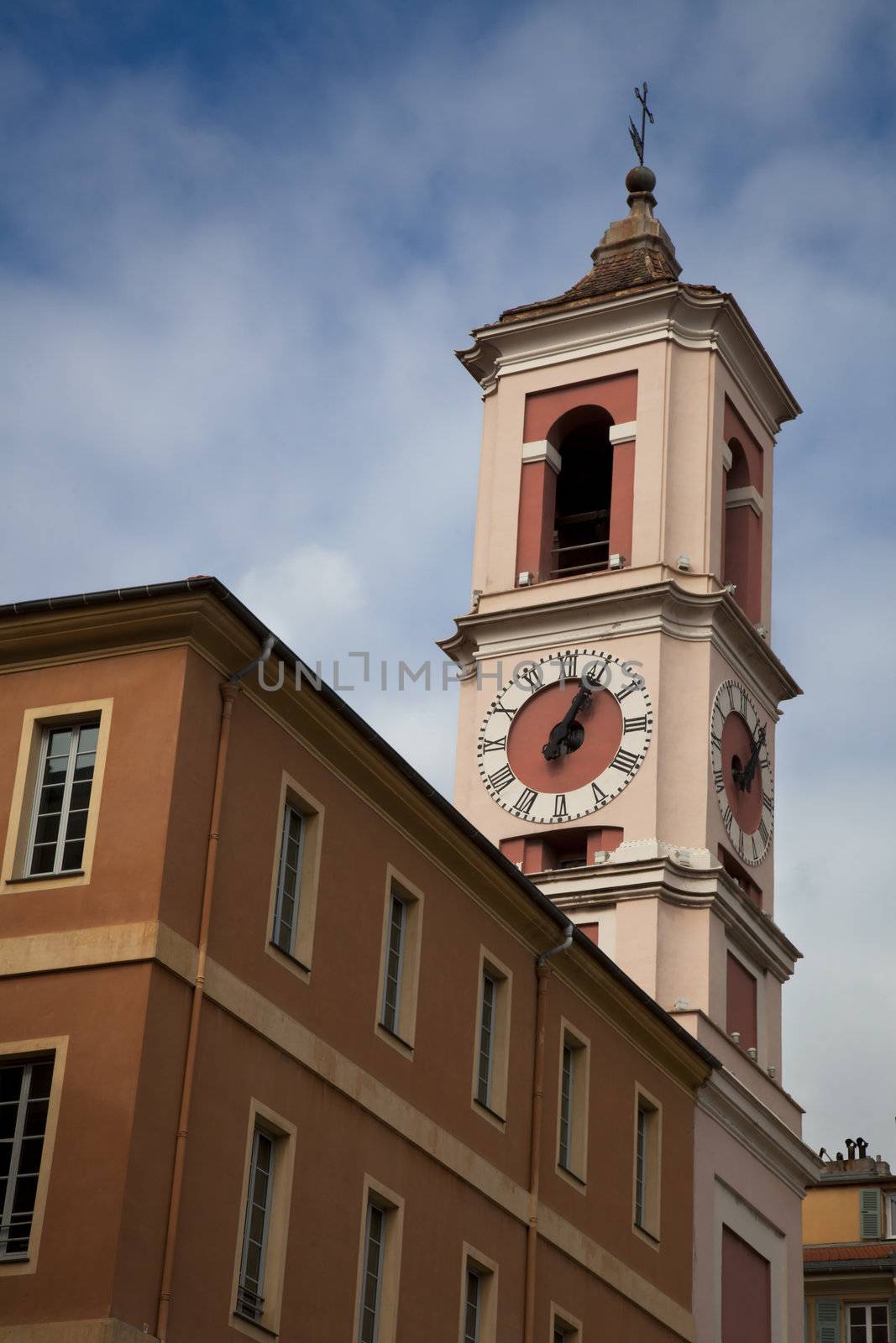 Clock tower of Rusca Palace in Nice France, on a cloudy day.