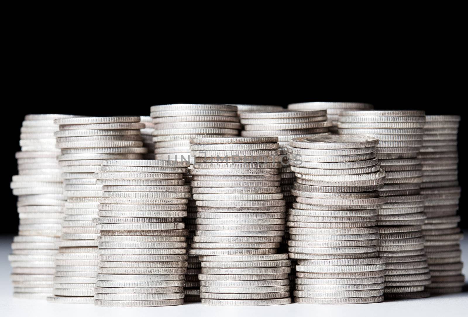 Many stacks of old silver dimes face on to camera