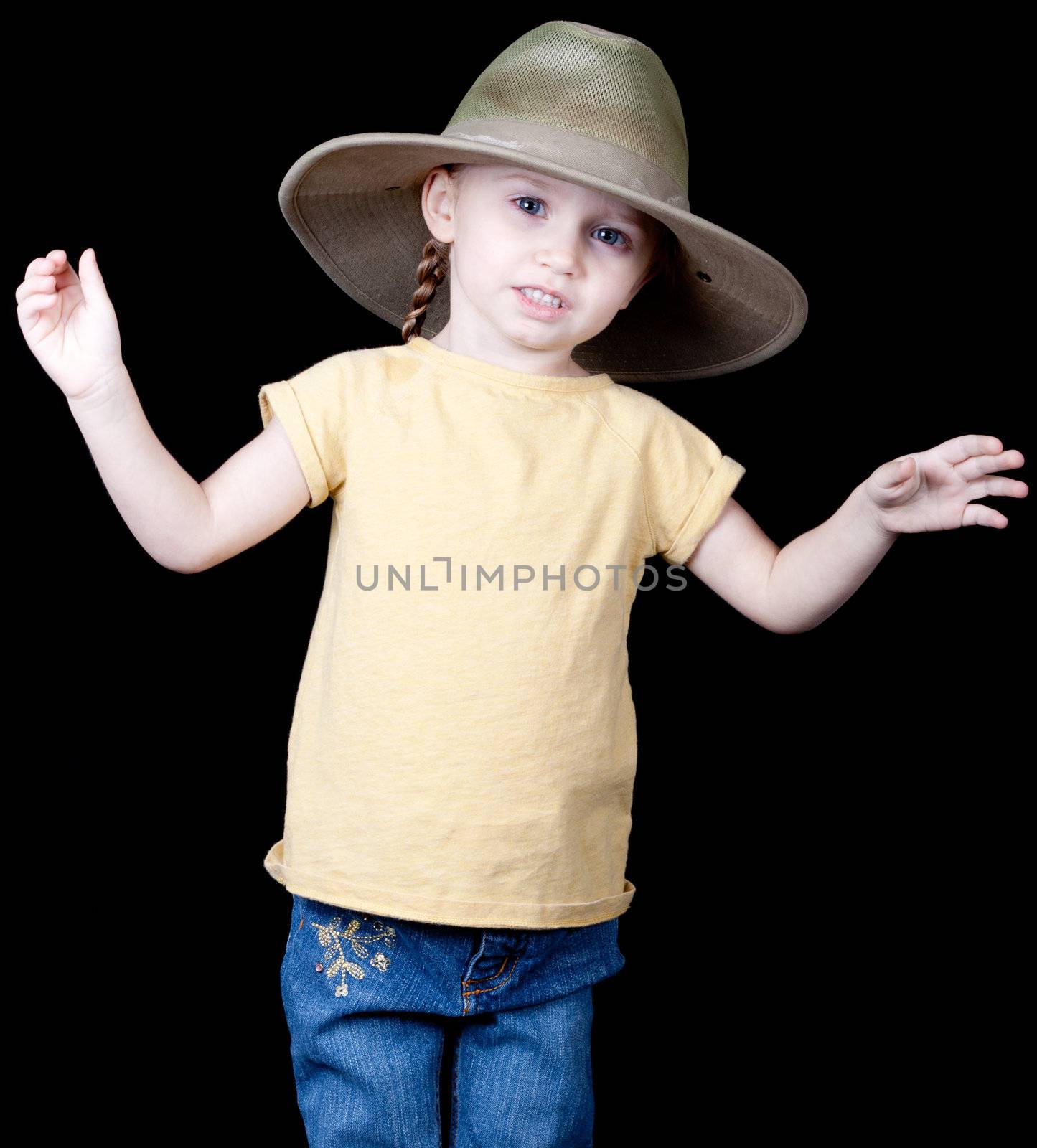 An adorable young child with an oversized hat on.  She looks as if she is explaining something.