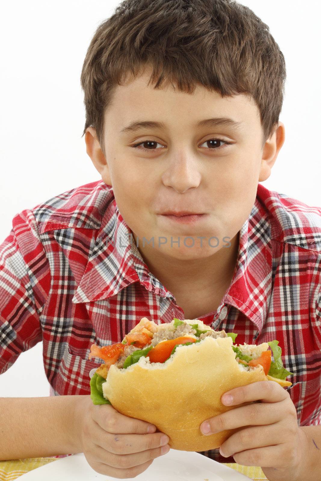 boy eating a big hamburger close up