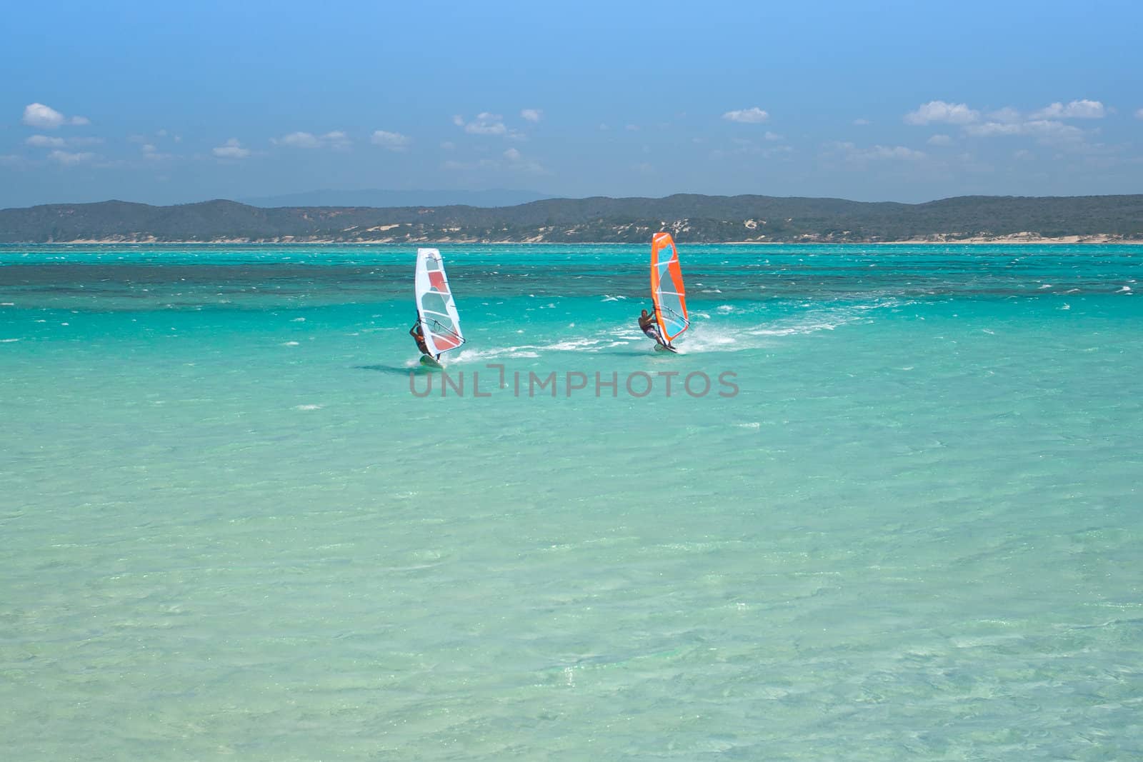 Couple man and woman windsurfing in the lagoon