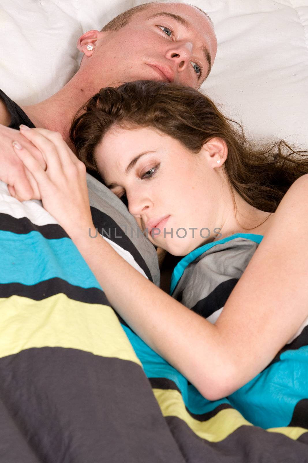 Young couple in bed sleeping while touching by DNFStyle