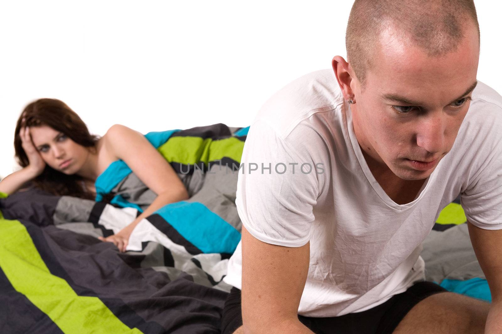 A young couple in bed with relation problems