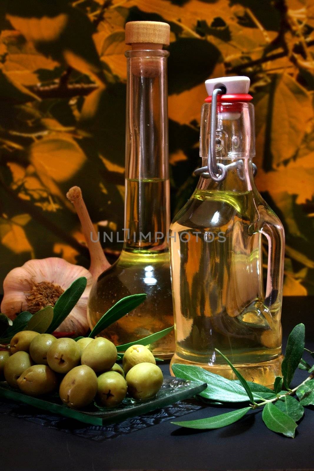 Olive oil with olive branch and fresh ingredients