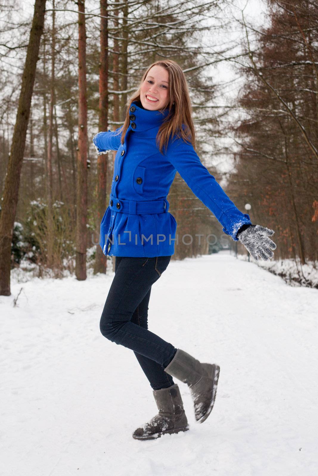 Cute girl posing silly on a snowy forest road