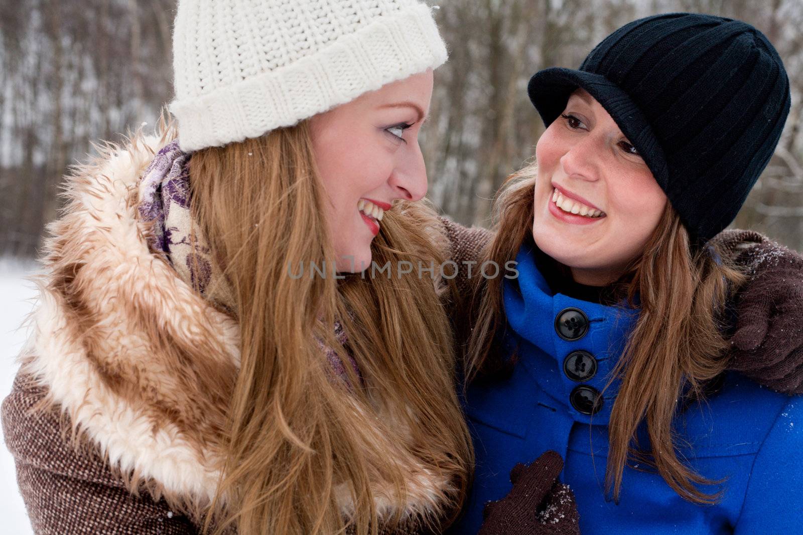 sisters smiling at eachother in winter time
