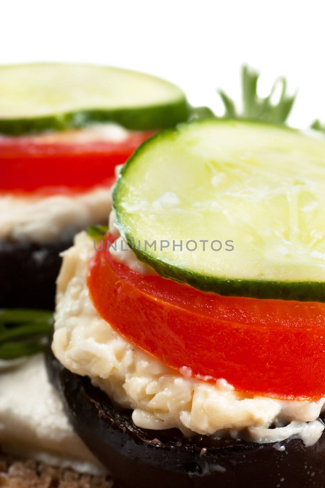 Open sandwich with aubergine and cucumbers over white background