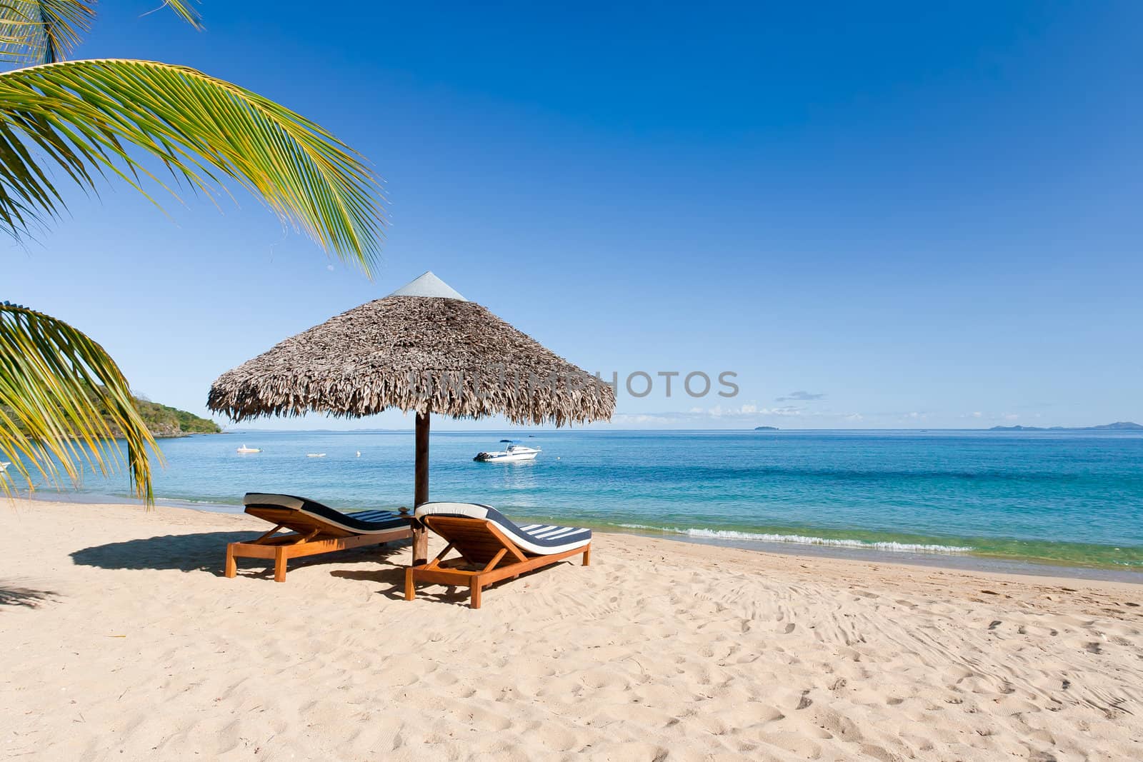 Tropical beach landscape with deckchair and parasol, from Nosy Be, Madagascar