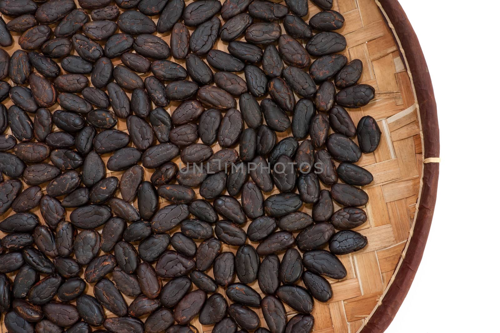 Cocoa beans from Madagascar in craft basket isolated on white background