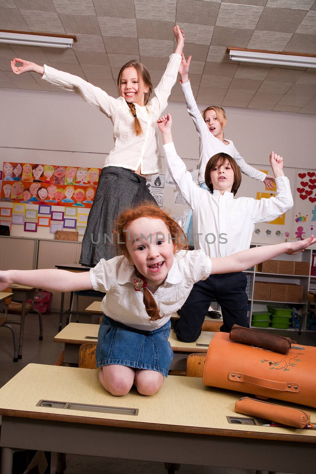 Group of little students with different ages in a classroom