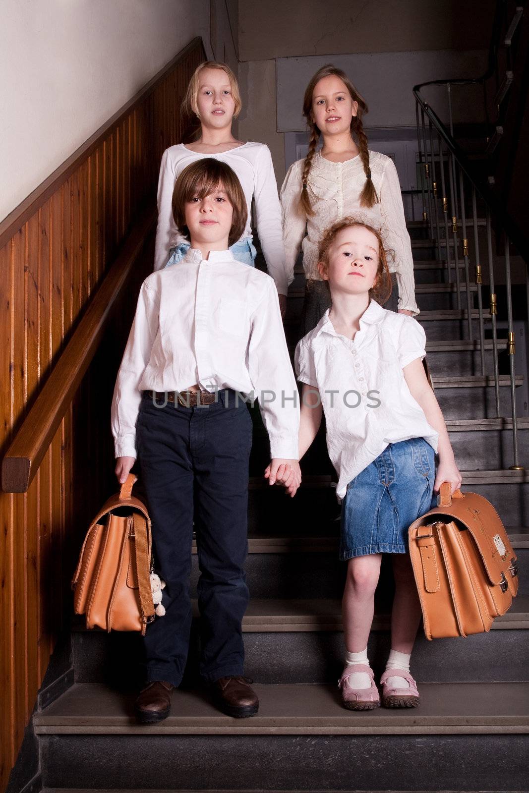 Group of little students with different ageson the stairs