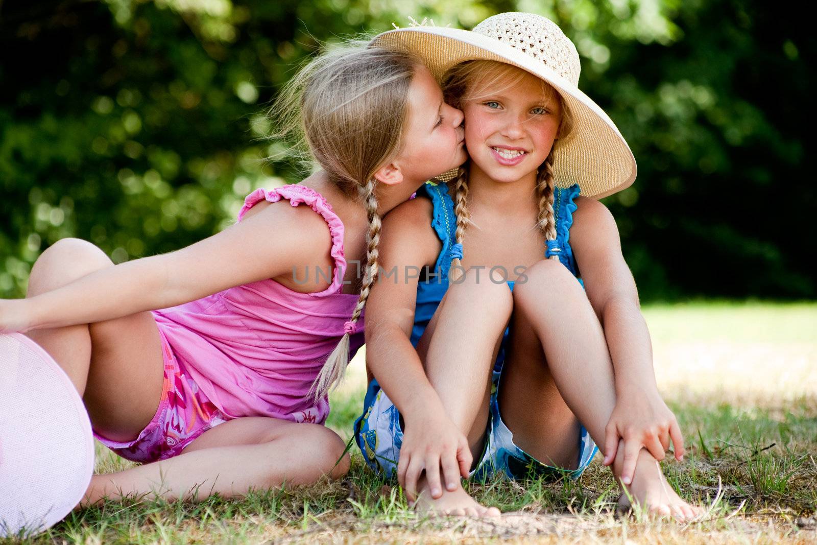 Two little girls in fresh colors in the park