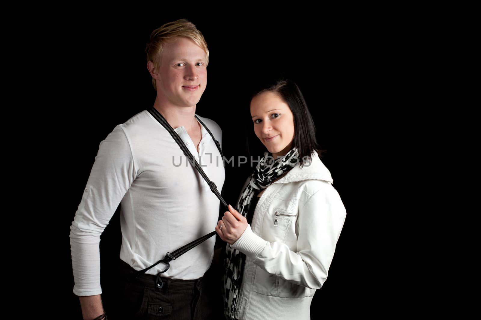 a young woman stretching the suspenders of a young man