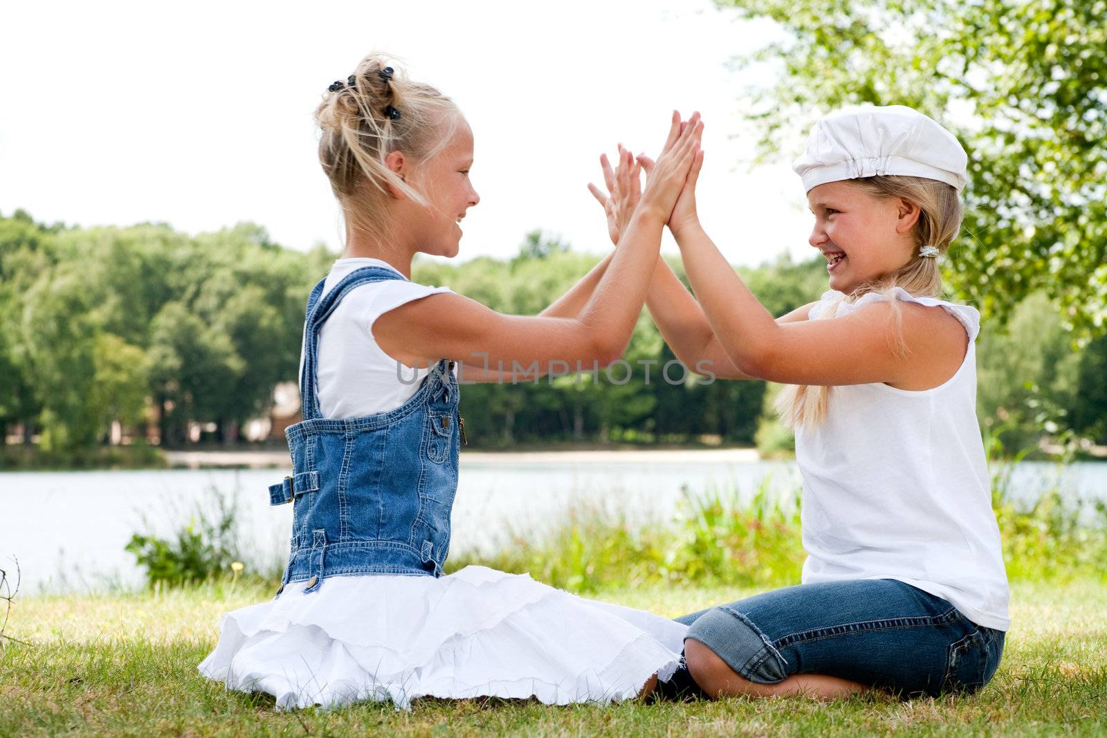 Two little girls in fresh colors in the park