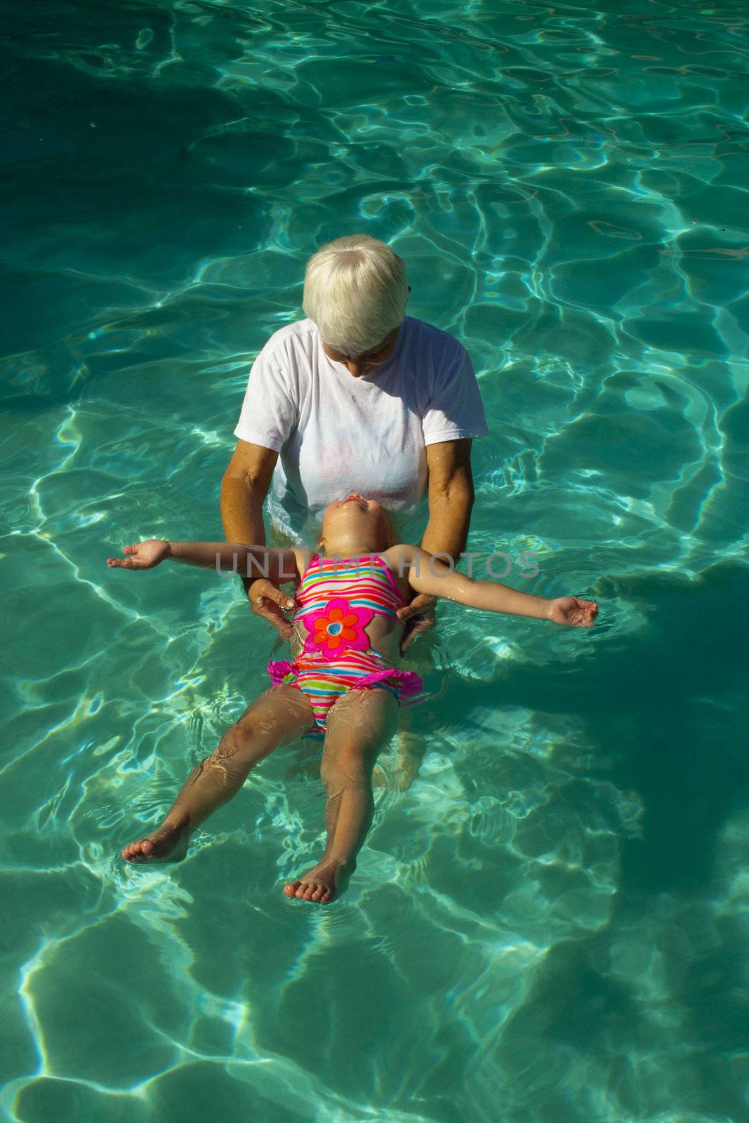 Grandmother giving granddaughter swim lessons