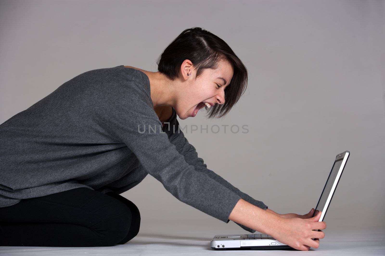 Studio shot of a multi raced yopung woman with her laptop on the floor