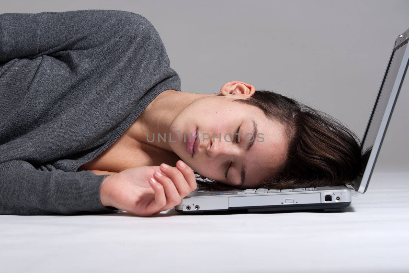 Studio shot of a multi raced yopung woman with her laptop on the floor