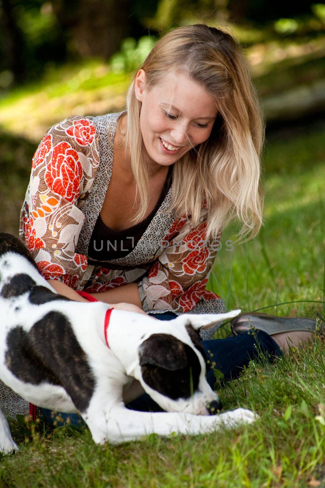 Blond girl and a american bulldog in the park