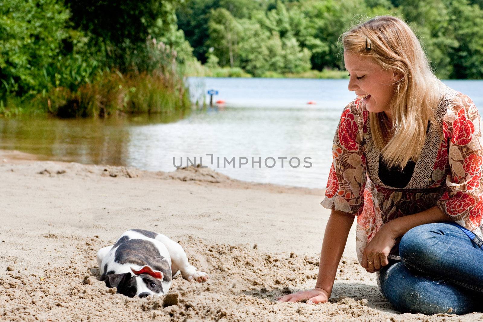 Blond girl and a american bulldog in the park
