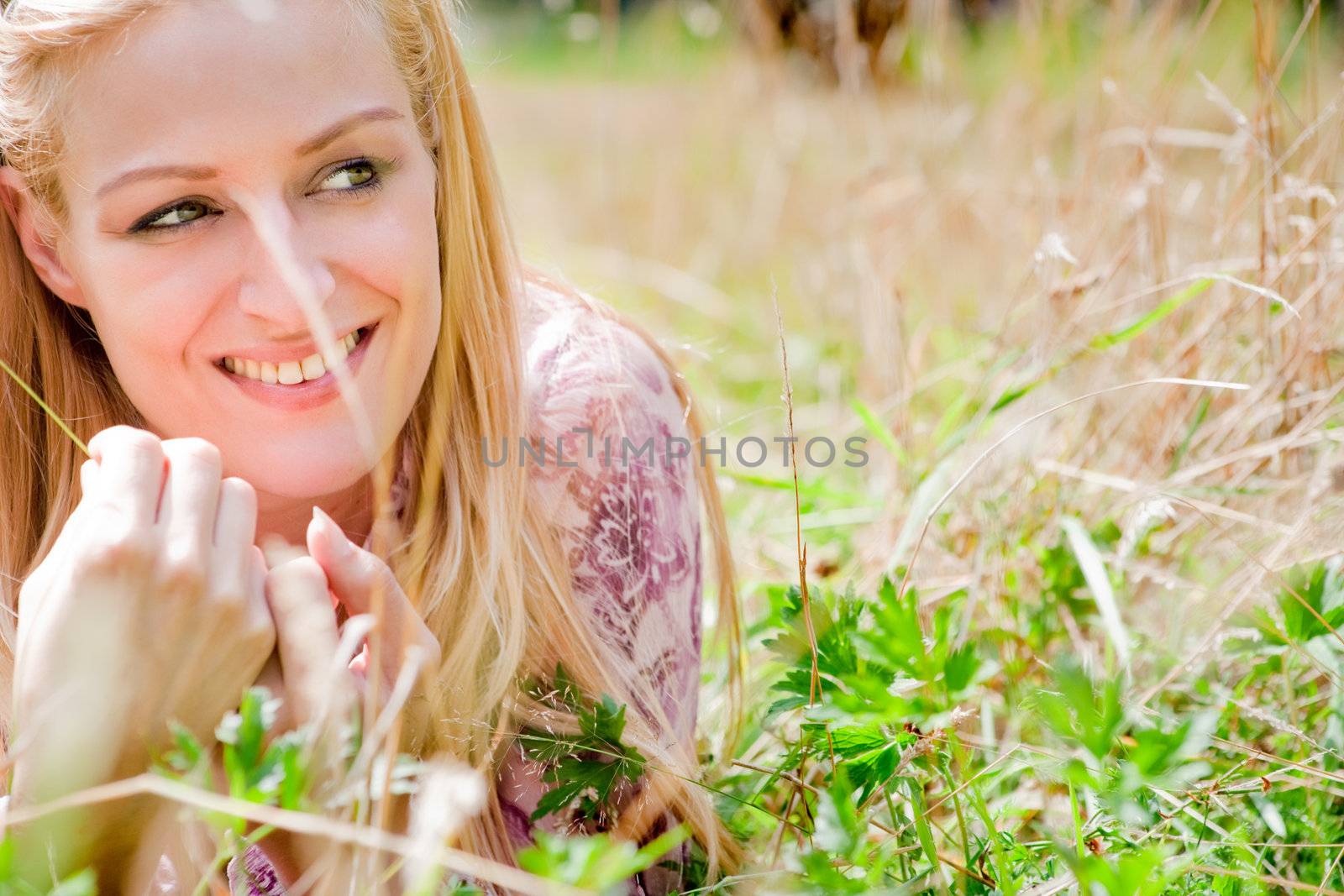 A blond woman in the park with sunny weather