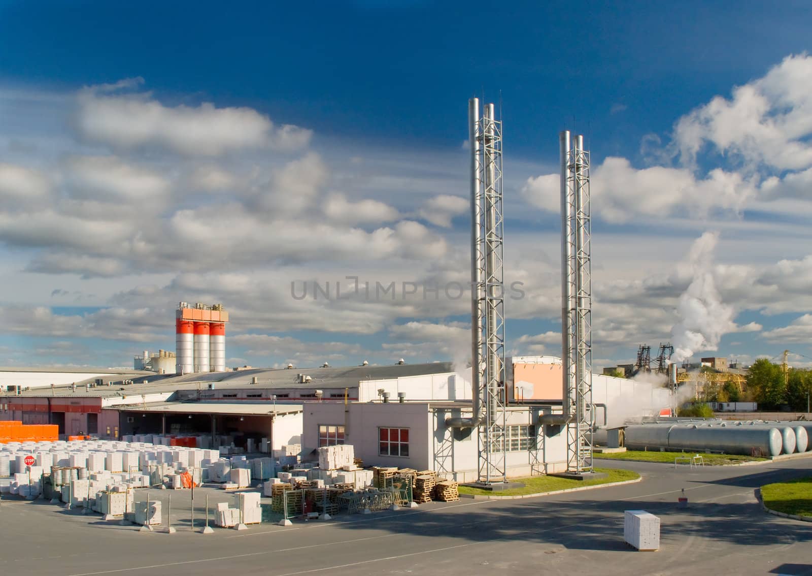 Factory with a chimney and smoke in sunny day