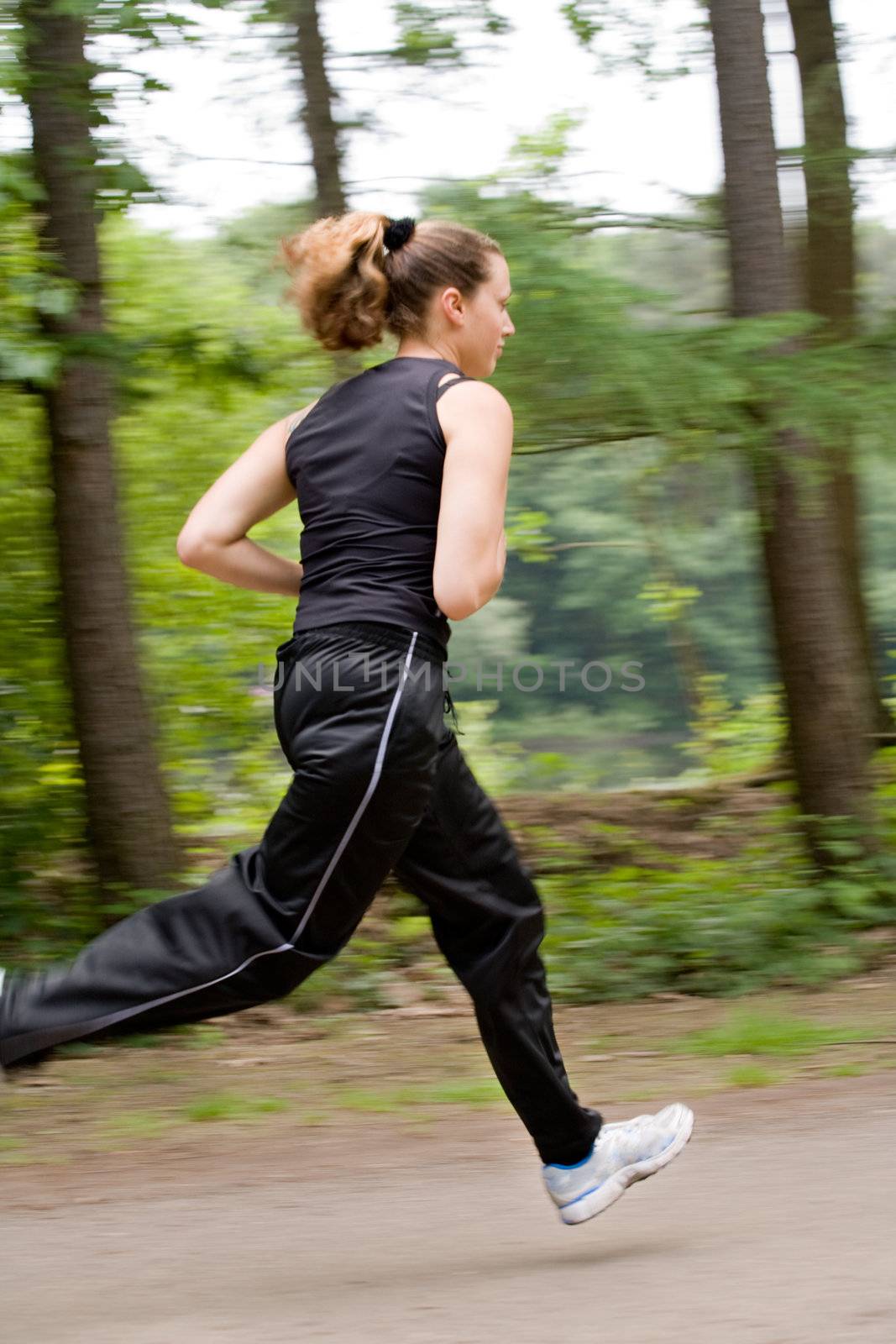 Young adult jogging on a forest road