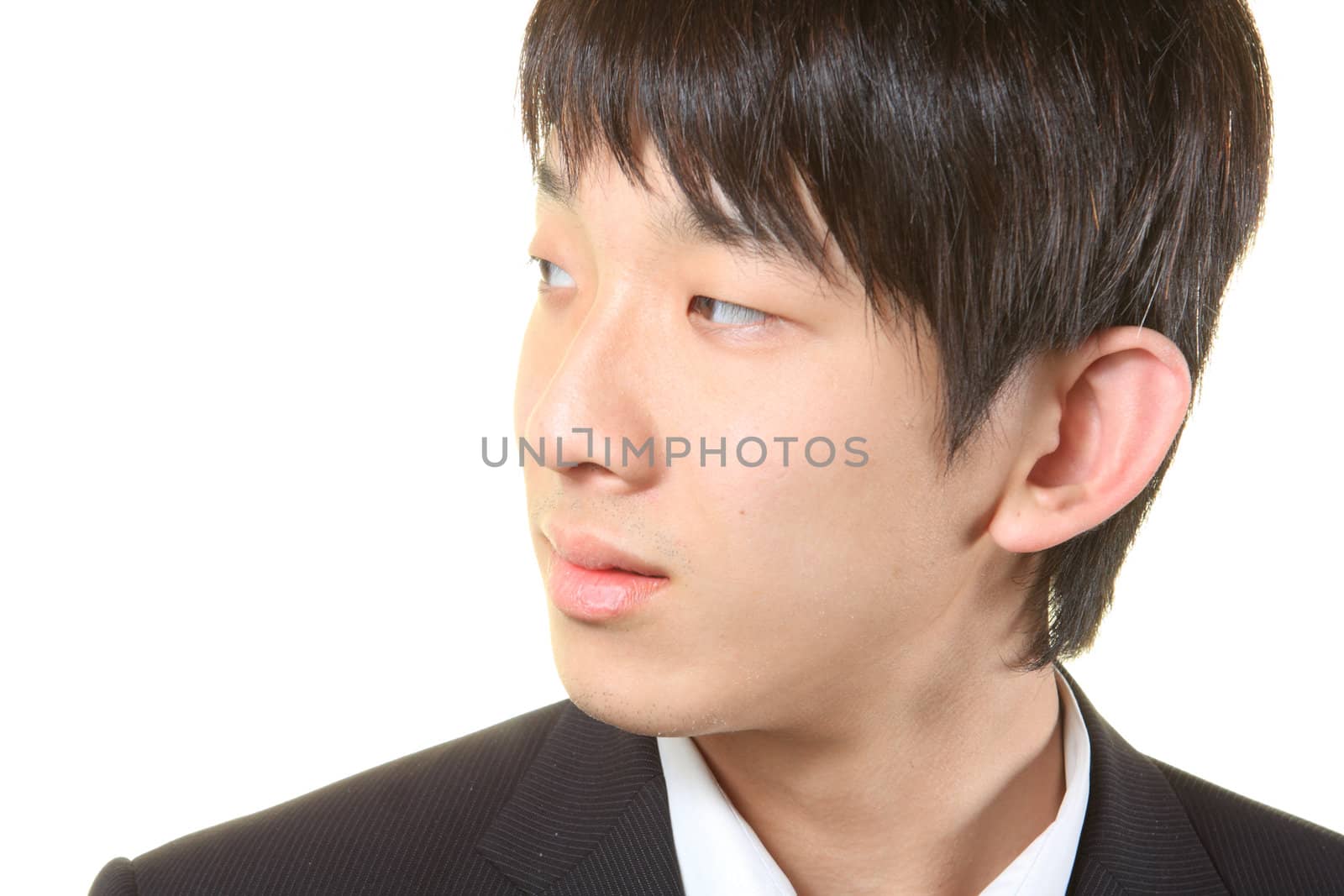 Young businessman standing and looking right on white background.