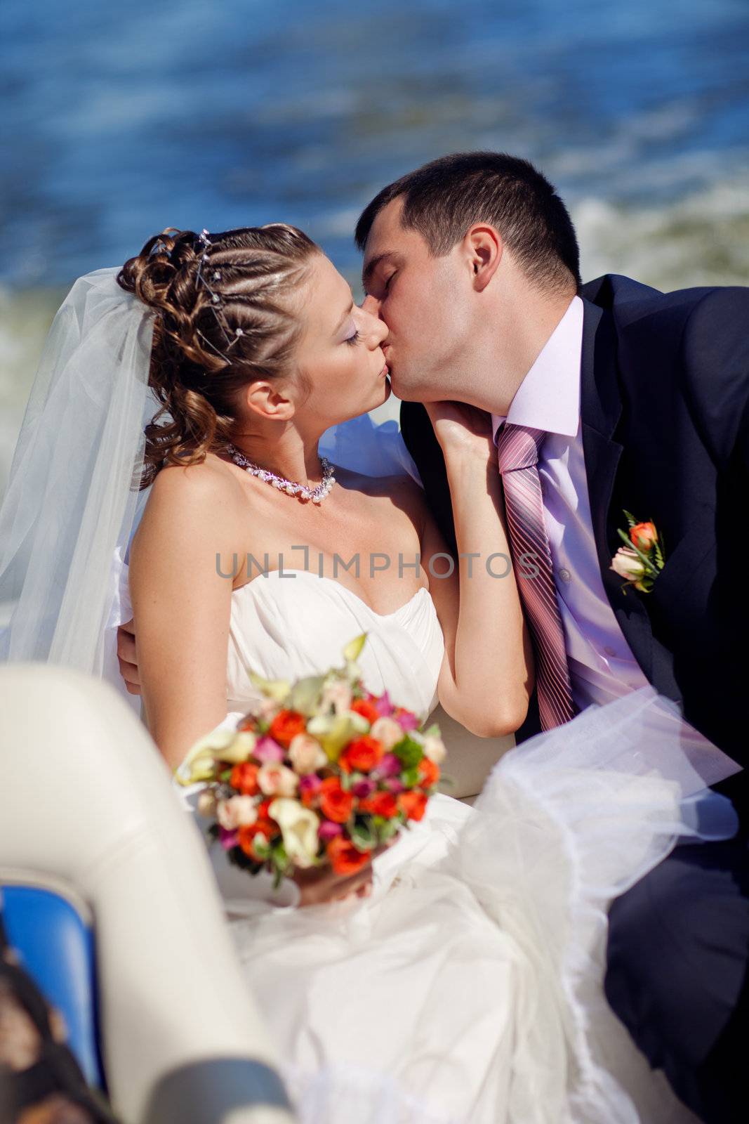 bride and groom kissing on the boat