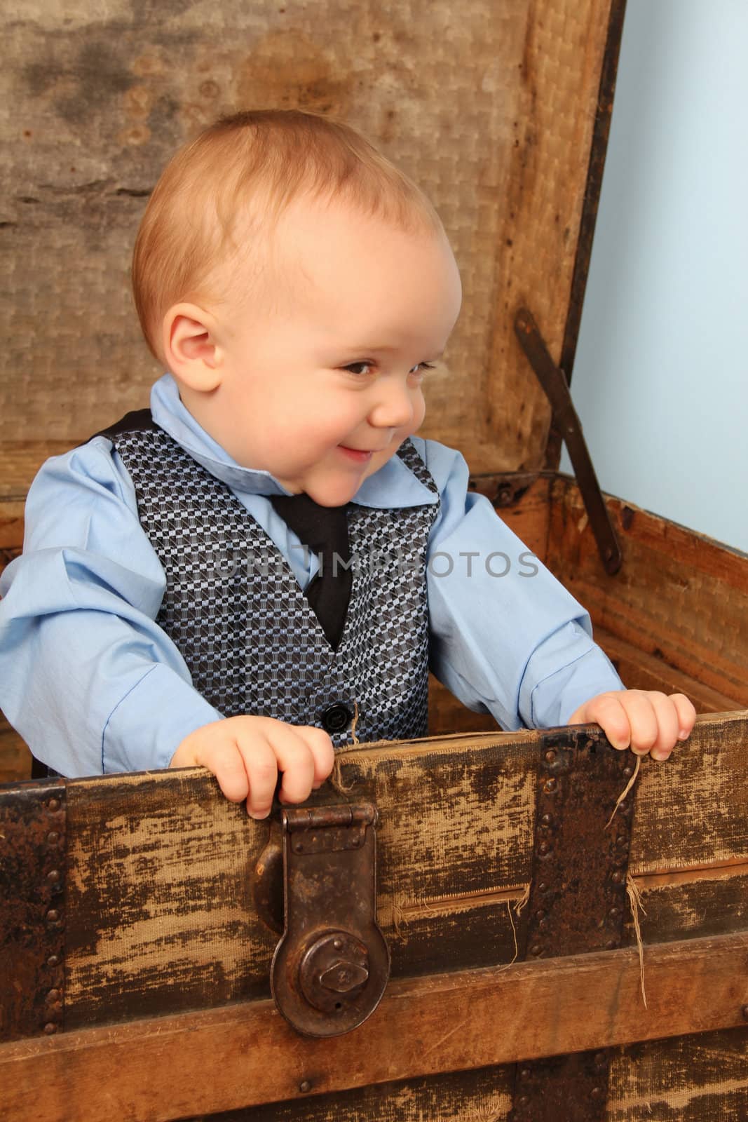 Baby boy playing inside an antique trunk