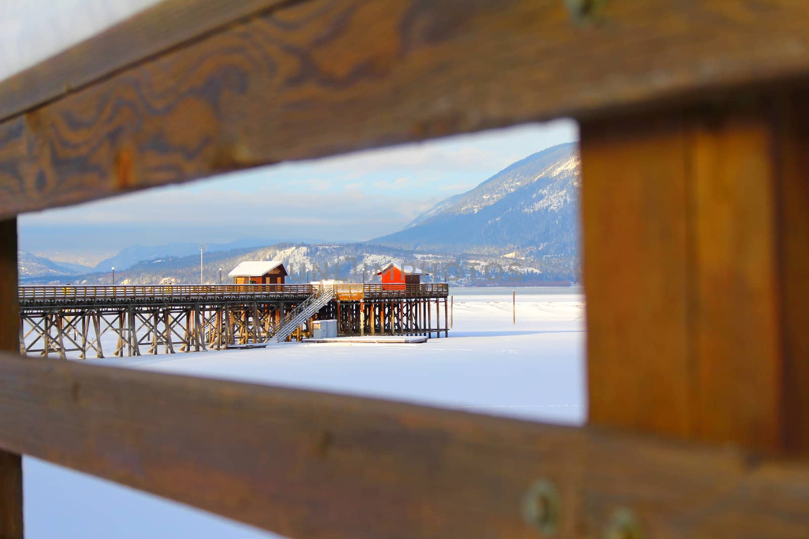 Wooden pier with snow at frozen lake in Salmon Arm 