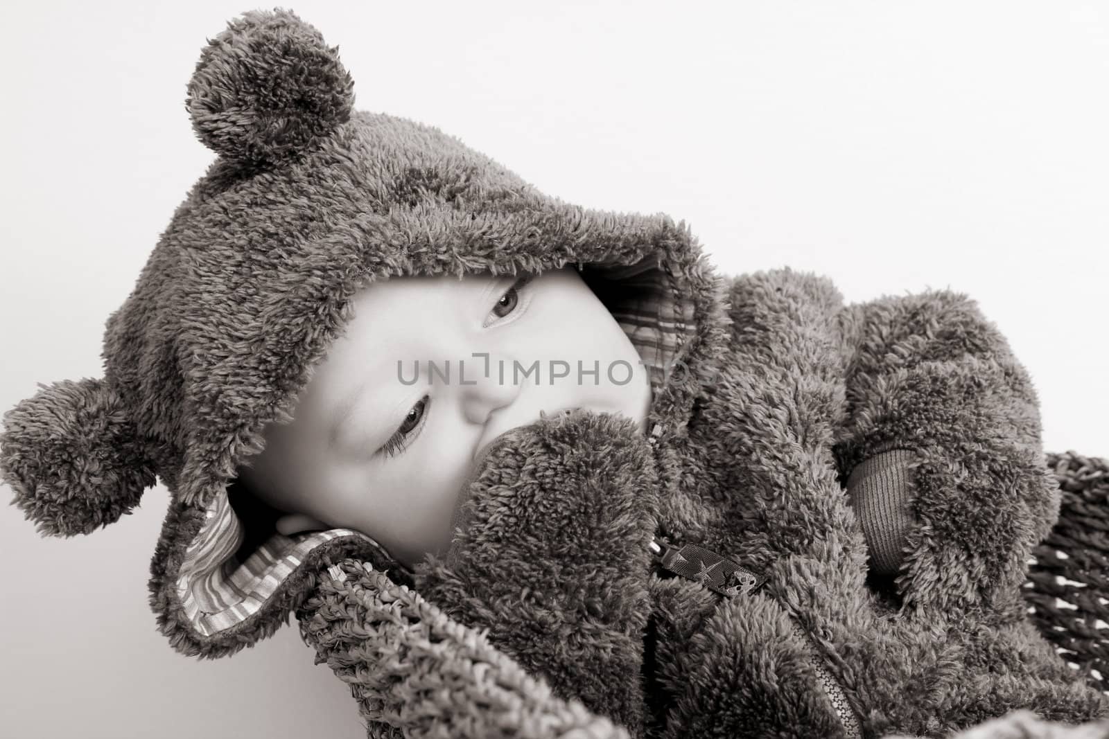 Four month old baby boy wearing a fully bear suit
