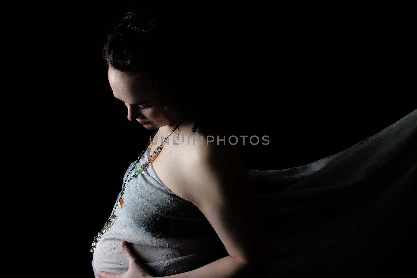 Beautiful pregnant lady against a black background