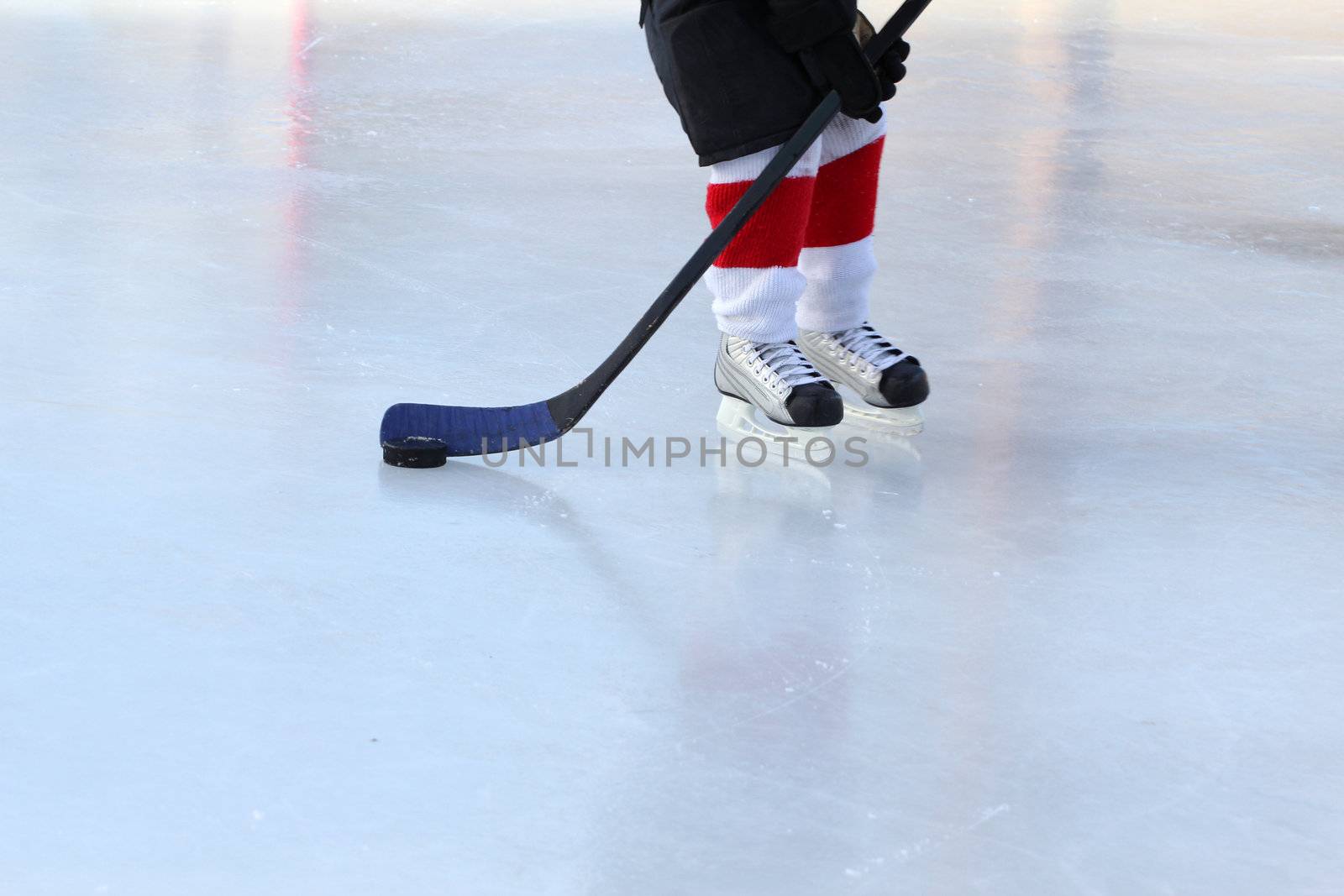 Young hockey player practising on a frozen pond