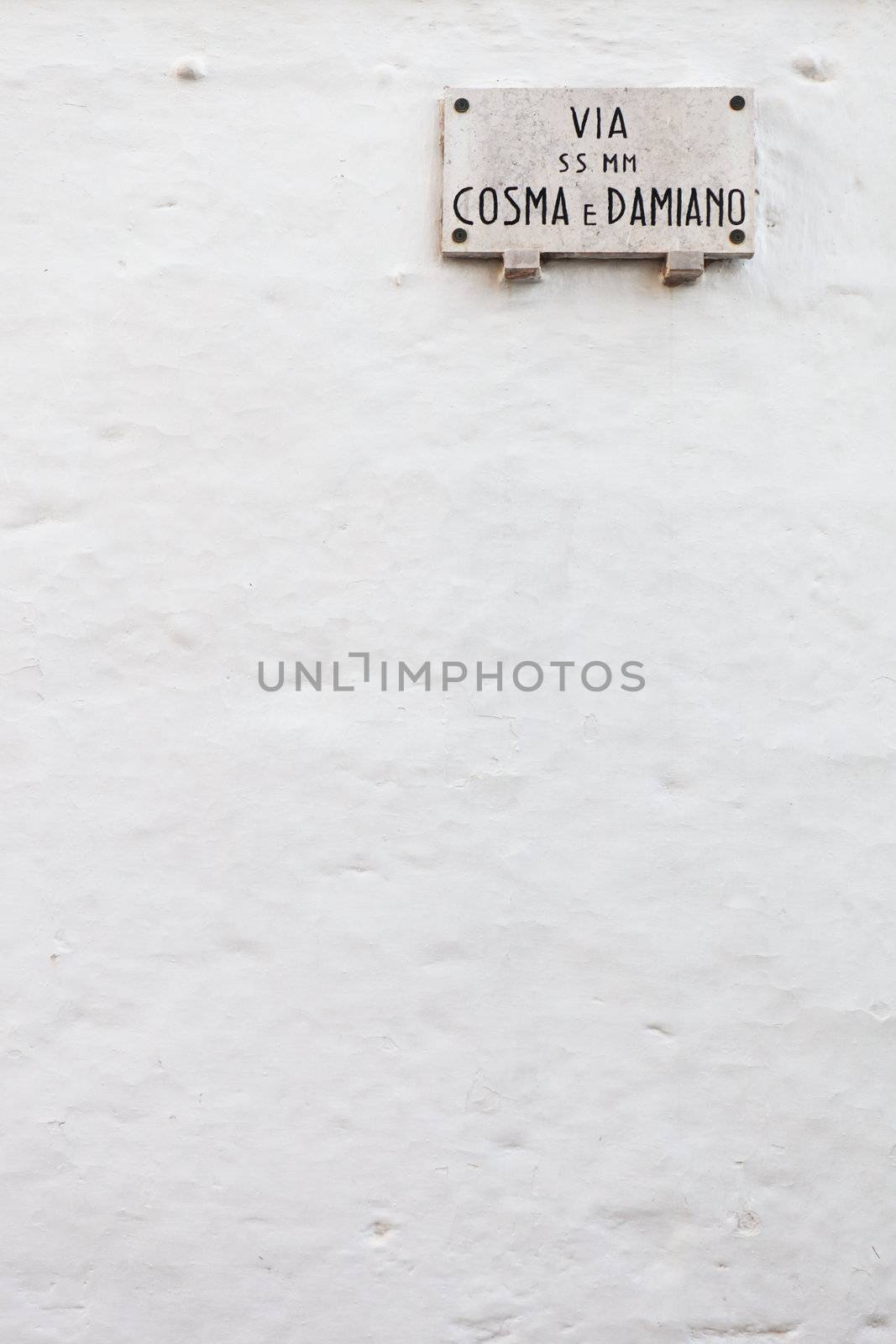 Italian street name plate on a white painted wall