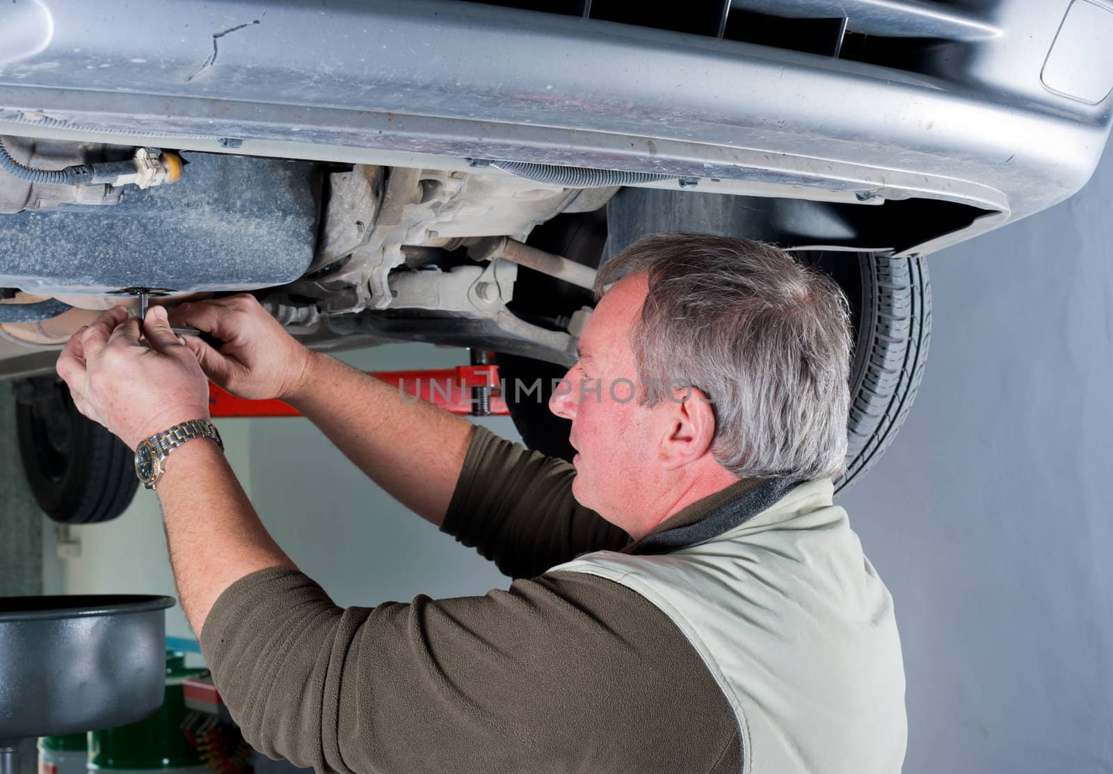 Car mechanic doing the final check after changing oil