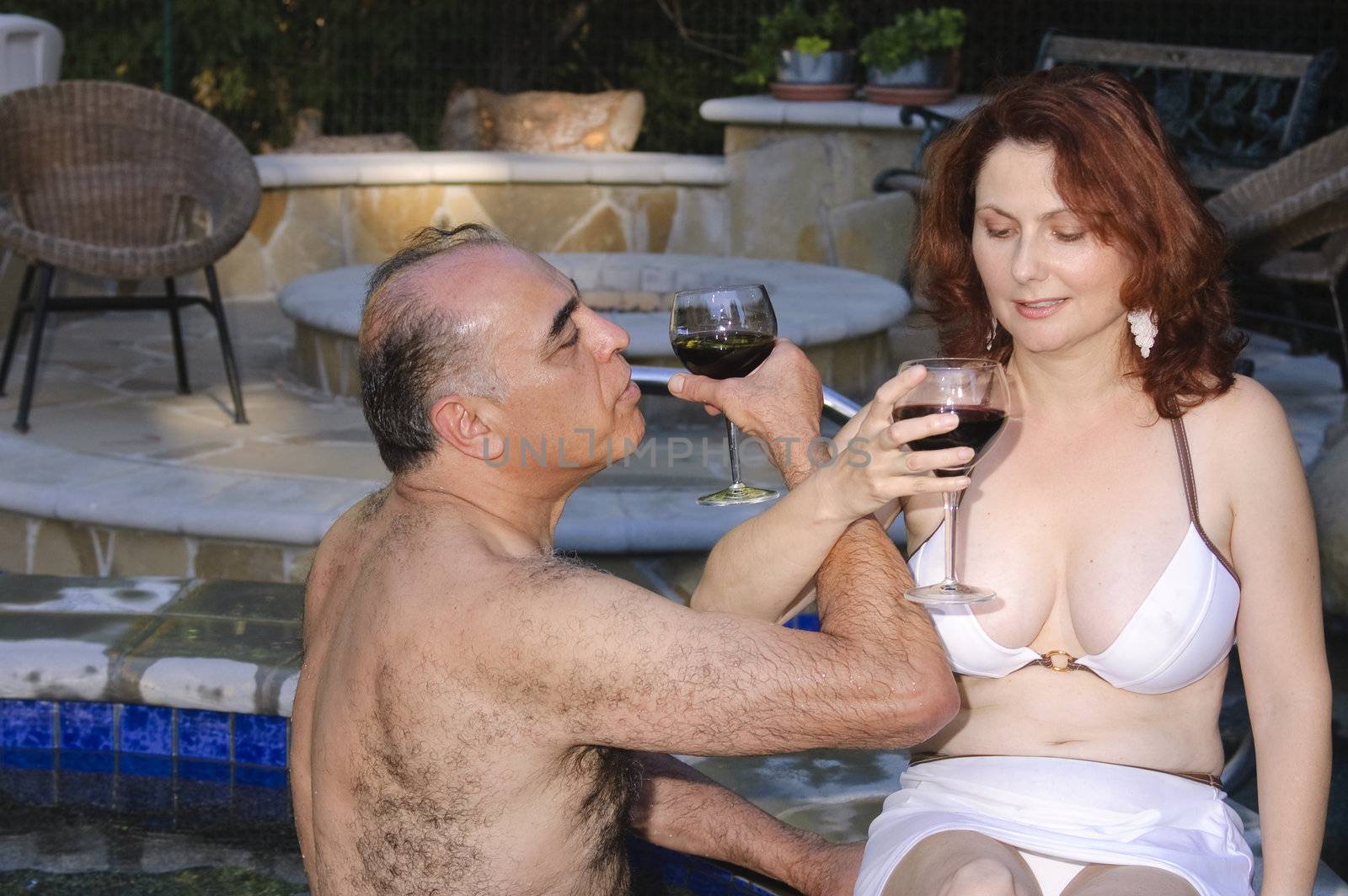 Middle-eastern Man and Hispanic woman enjoying laughter while in a hot tub