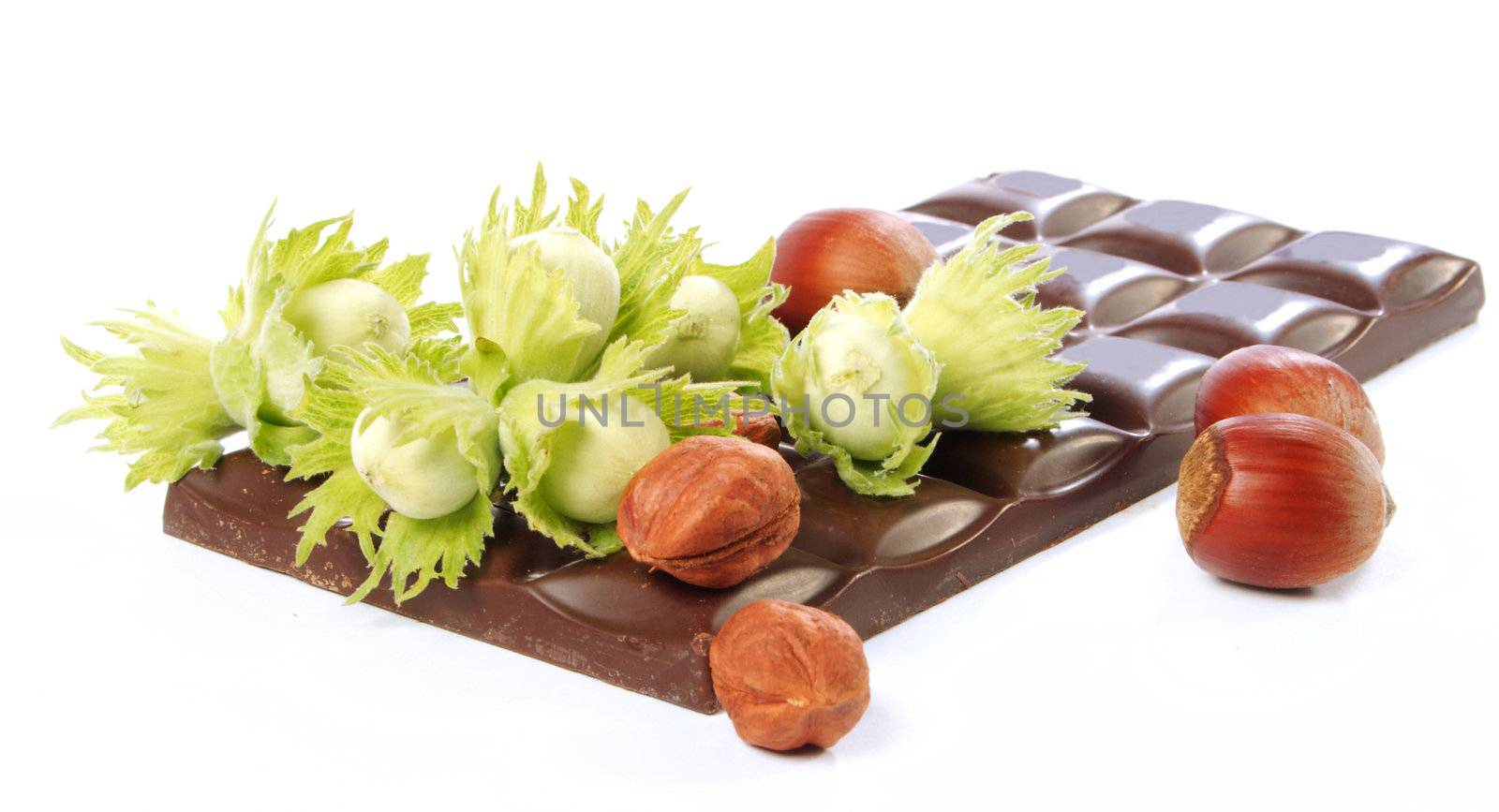 Piece of chocolate and wood nuts on a white background
